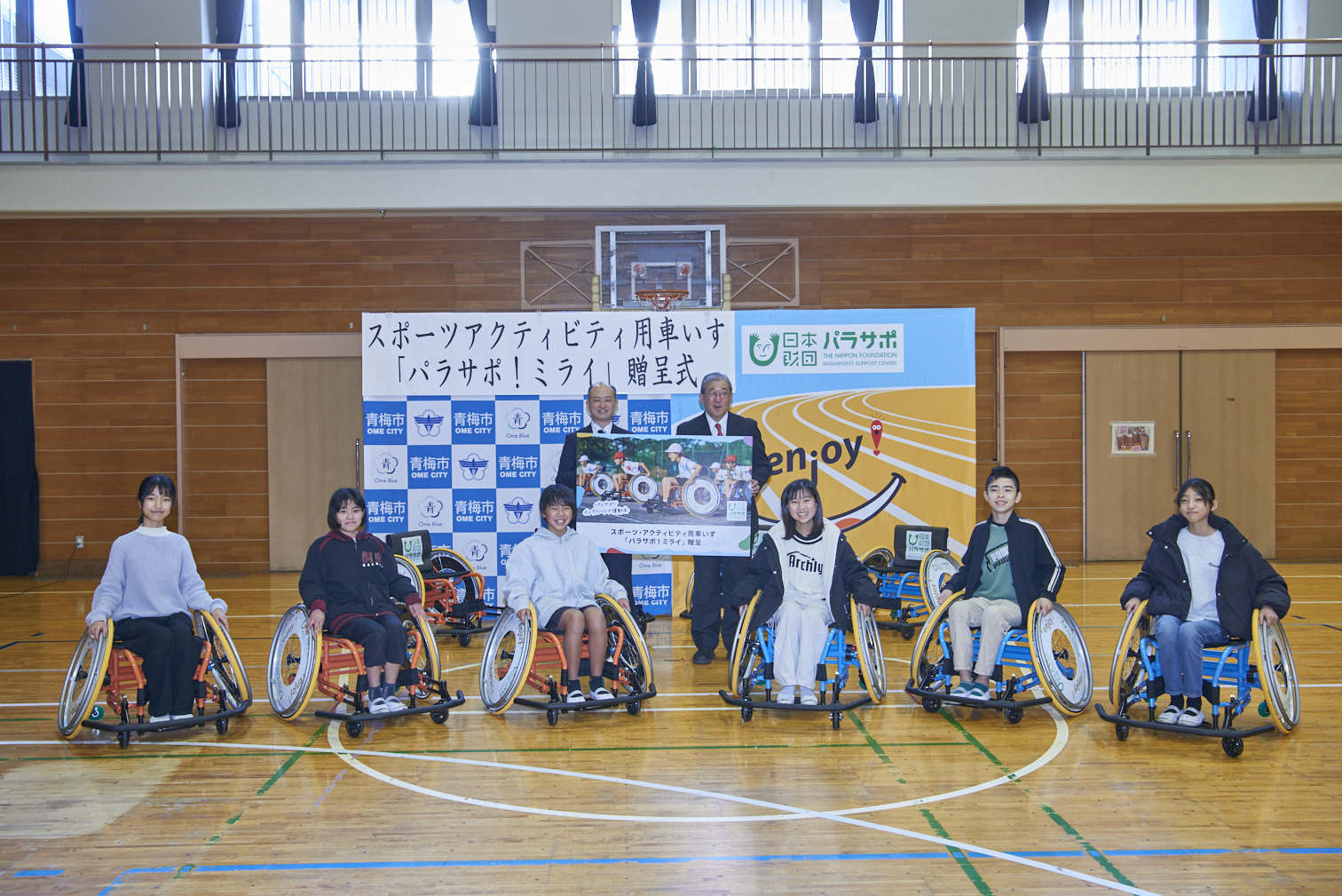 西多摩地区では初、東京都青梅市へ「パラサポ！ミライ」10台を贈呈。市長と児童が体育館で「パラサポ！ミライ」に試乗